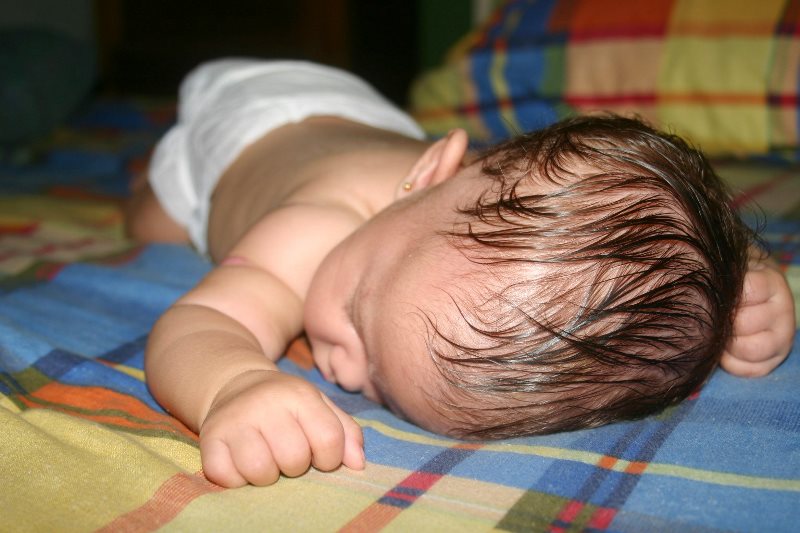 Почему грудничок вспотел во время кормления и сна: причины потливости головы
